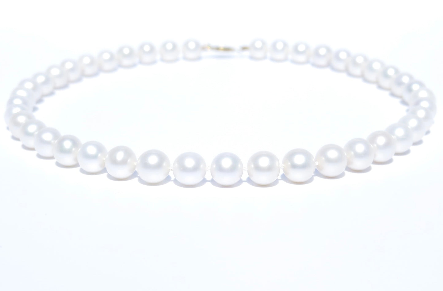 This pearl jewelry is a work of art and each pearl is hand-picked and matched in Guelph, Ontario, Canada. This elegant and gorgeous white pearl necklace is handmade with 100% cultured freshwater pearls, 18K yellow gold and silk thread. Pearl Size: 9.5-10.5 mm; Pearl Strand Length: 46 cm. 